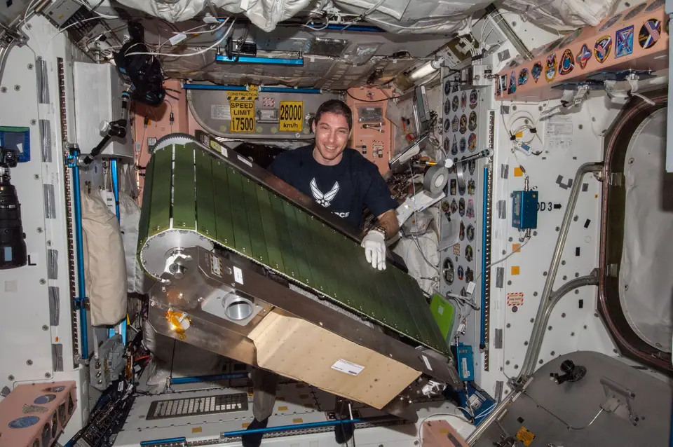 Astronauta corriendo sujeto con arneses en la cinta de ejercicio COLBERT de la Estación Espacial Internacional