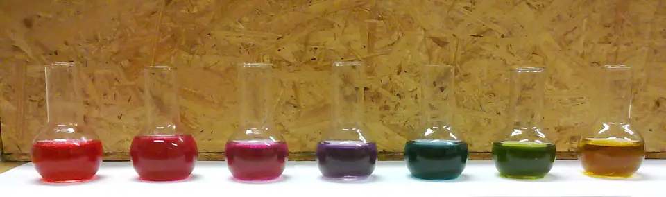 Frascos con extracto de repollo morado, un indicador natural de pH, que cambia de rojo a verde según la acidez del líquido
